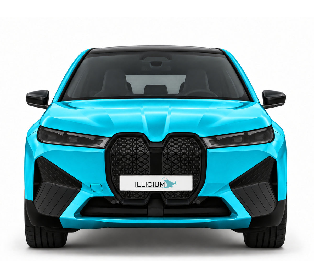 BMW iX I20 · M60 – Frontansicht in Türkis Metallic, schwarze Anbauteile, dunkle ausgeschaltete Scheinwerfer und Original-ILLICIUM-Kennzeichen